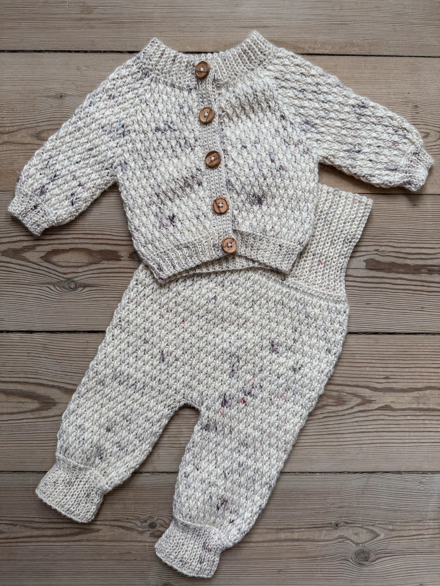 Close up af hæklet cardigan og hæklede bukser til baby