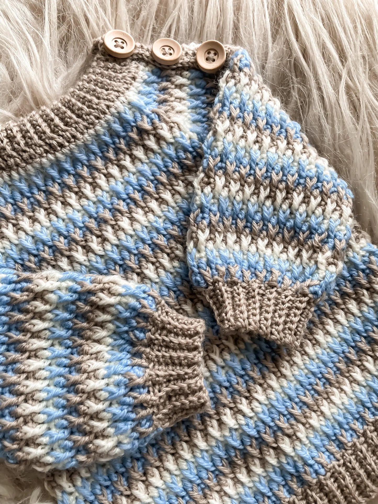 Close up af hæklet babysweater med striber