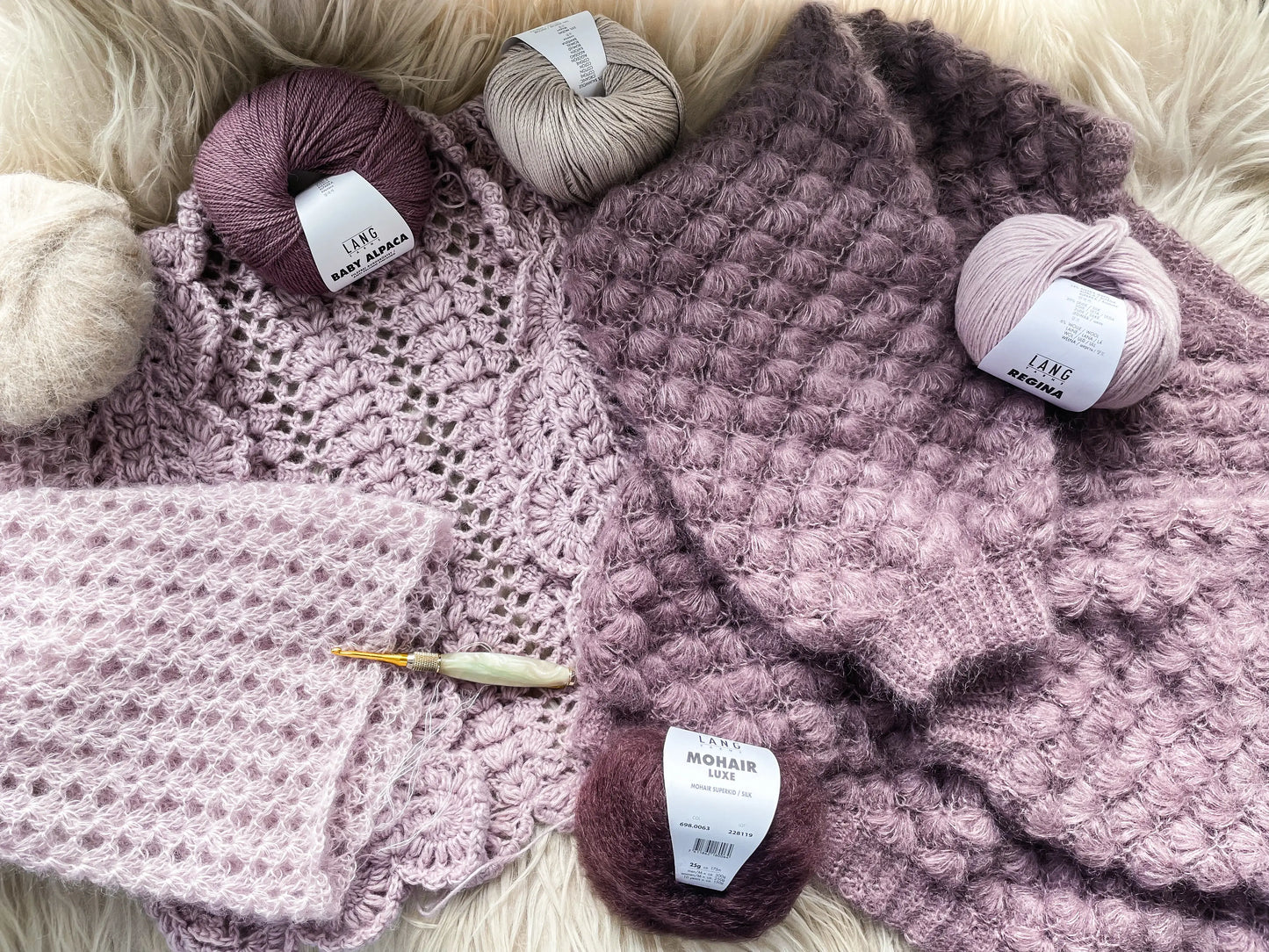 Hæklet sweater og cardigan med garnnøgler og hæklenål omkring